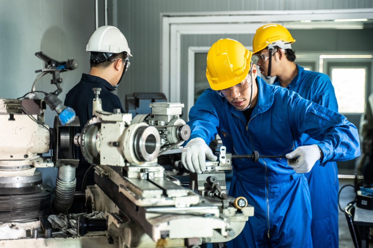 Asian mechanical technicians workers working on operating milling machine for safety precaution.