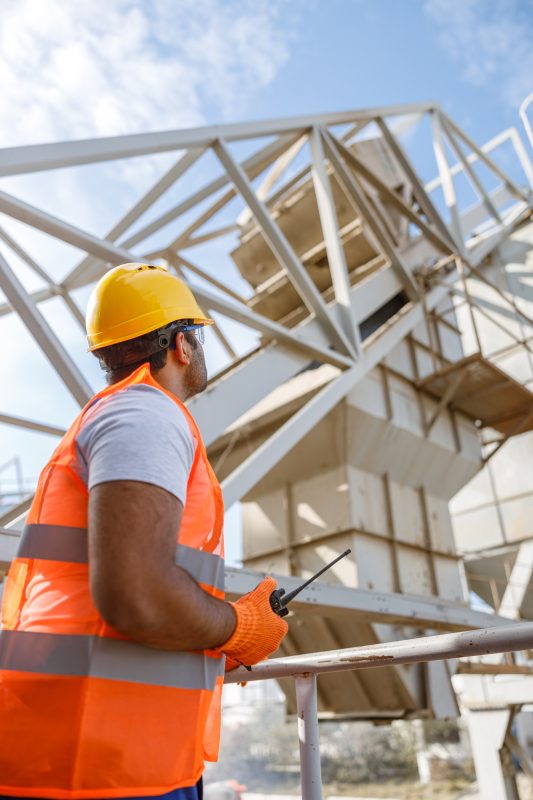 Worker with safety equipment working at building plant